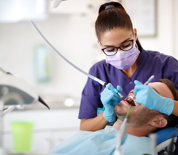 A hygienist cleaning a patient’s teeth